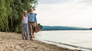 couple walking on the beach with picnic basket to avoid dehydration for proper kidney function